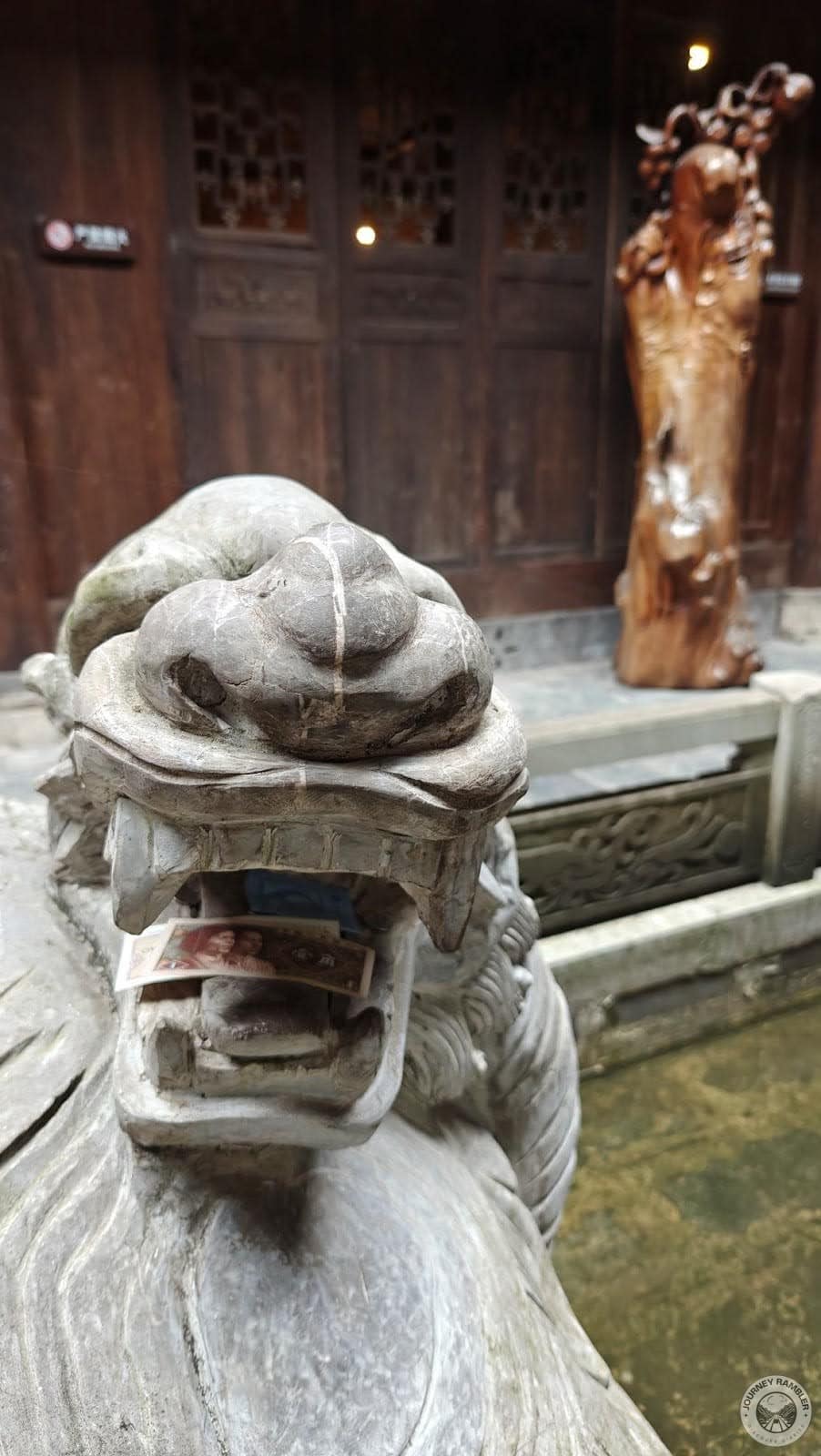 people place money on a Xuanwu sculpture