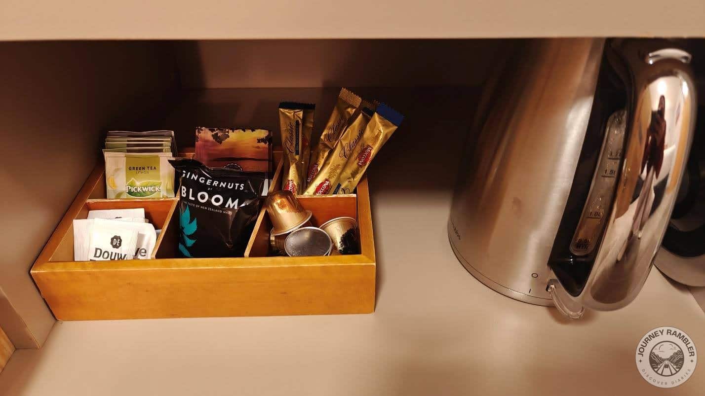 electric kettle and a tray of coffee filters, tea sachets, and sugar