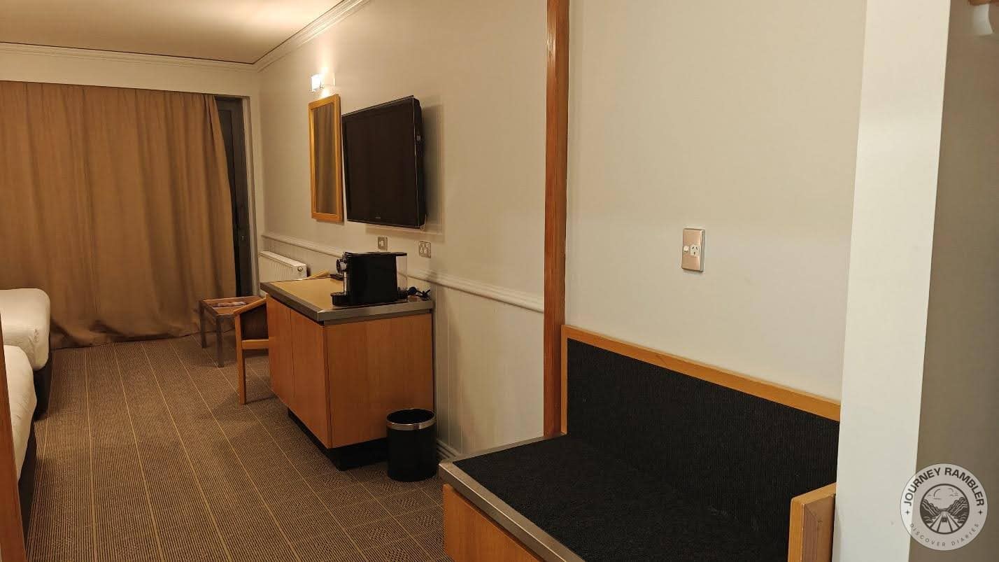 large screen TV on the wall opposite the beds