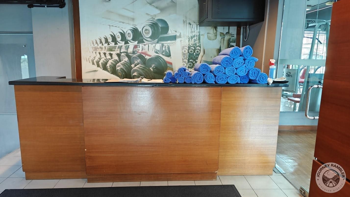 receptionist table that has a log book and towels of varying sizes on top