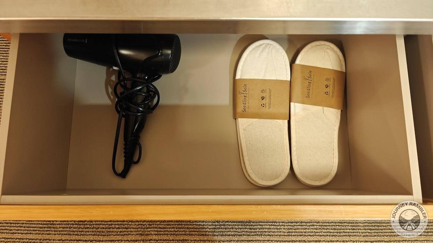 second drawer had a pair of bedroom slippers and a hair dryer