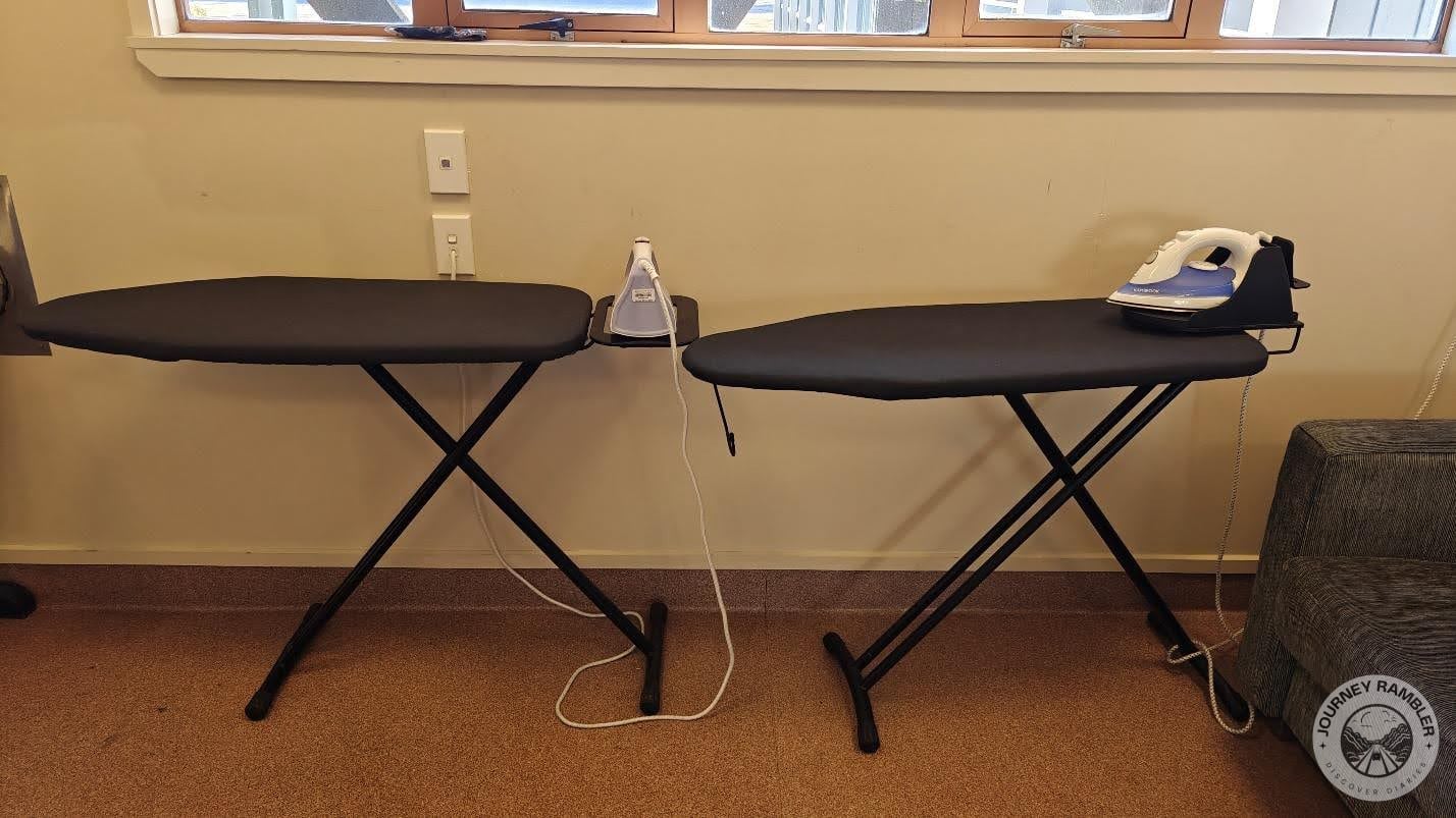 two ironing boards and irons inside the laundry room