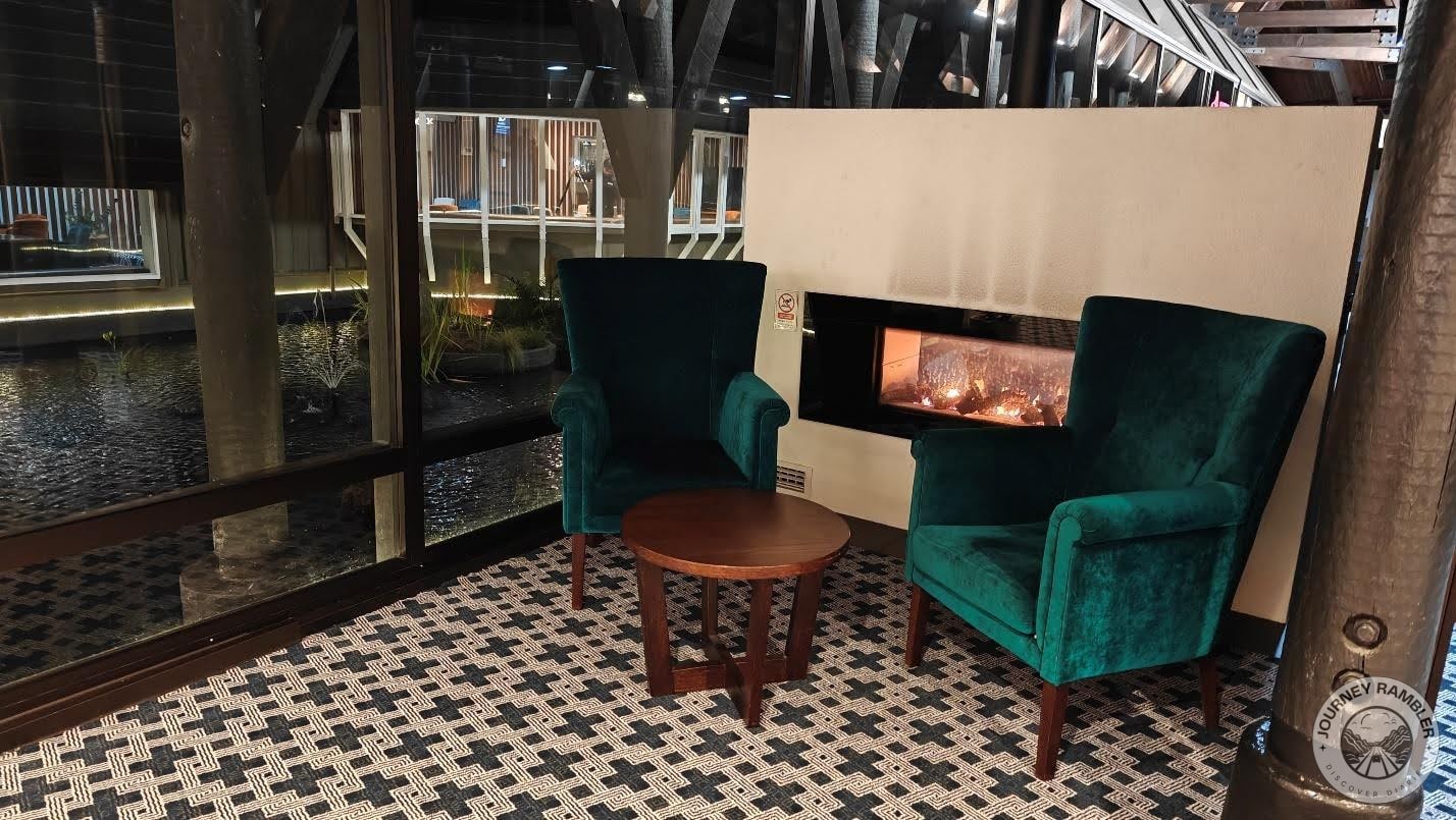 Two comfortable armchairs and a coffee table had been placed near a fireplace