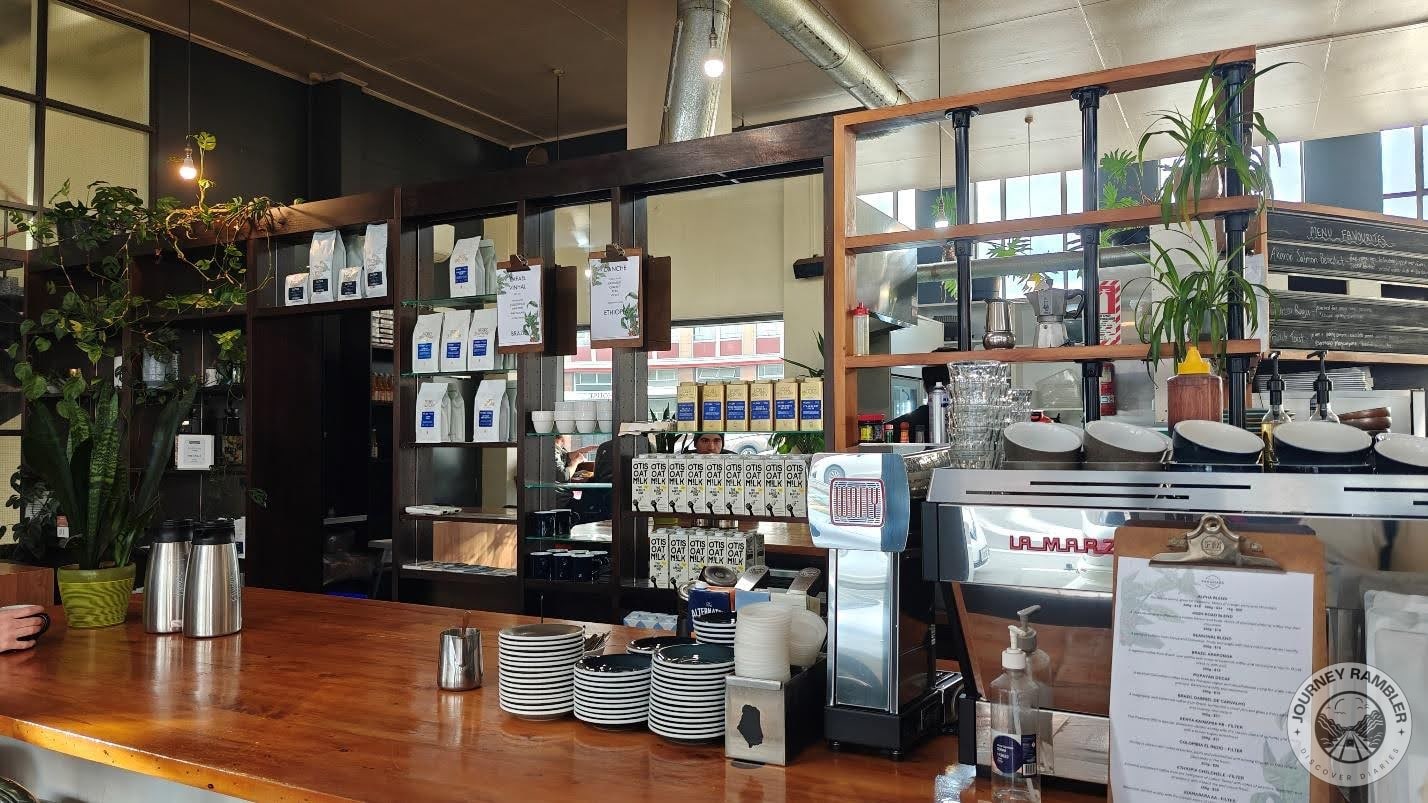 counter had a big coffee machine and lots of coffee cups and saucers