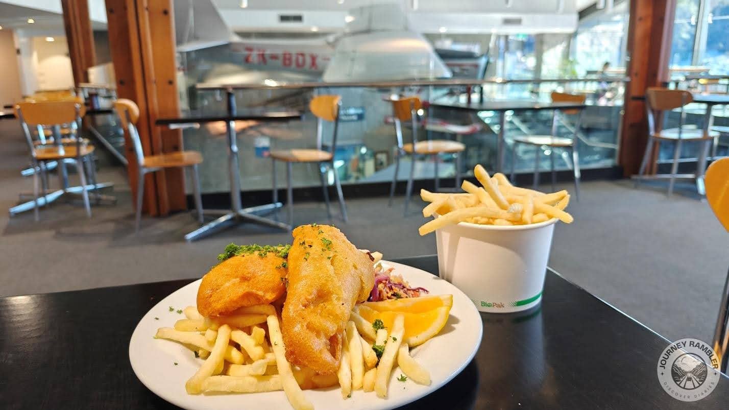 fish and chips with a side of salad and some lemon wedges