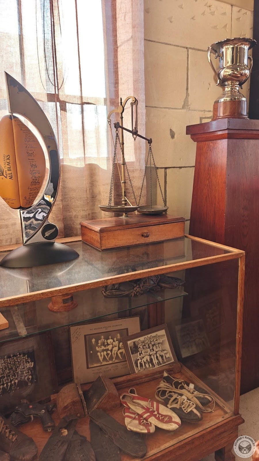 glass cabinets filled with old photos, shoes, guns and wooden blocks