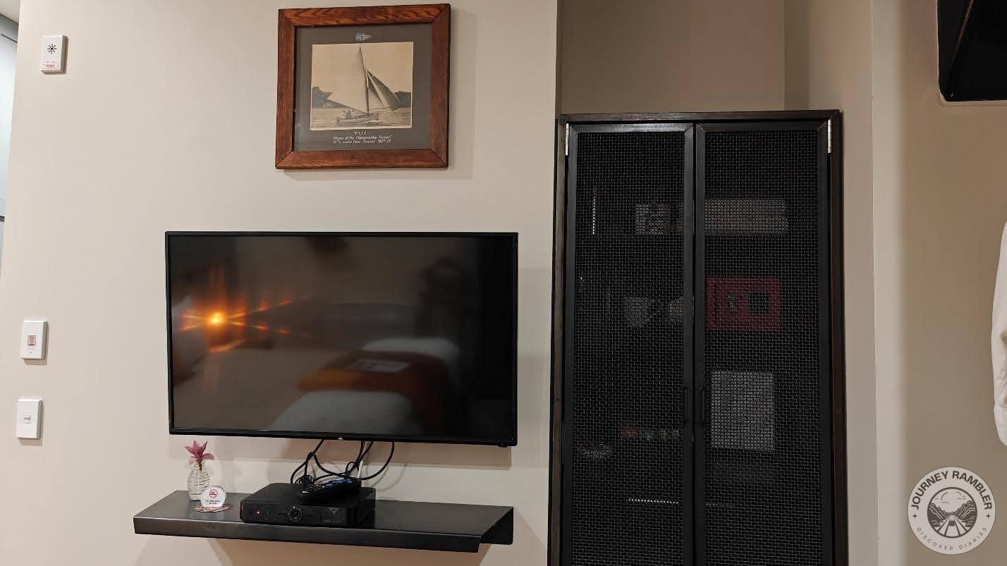large screen TV on the wall opposite the bed