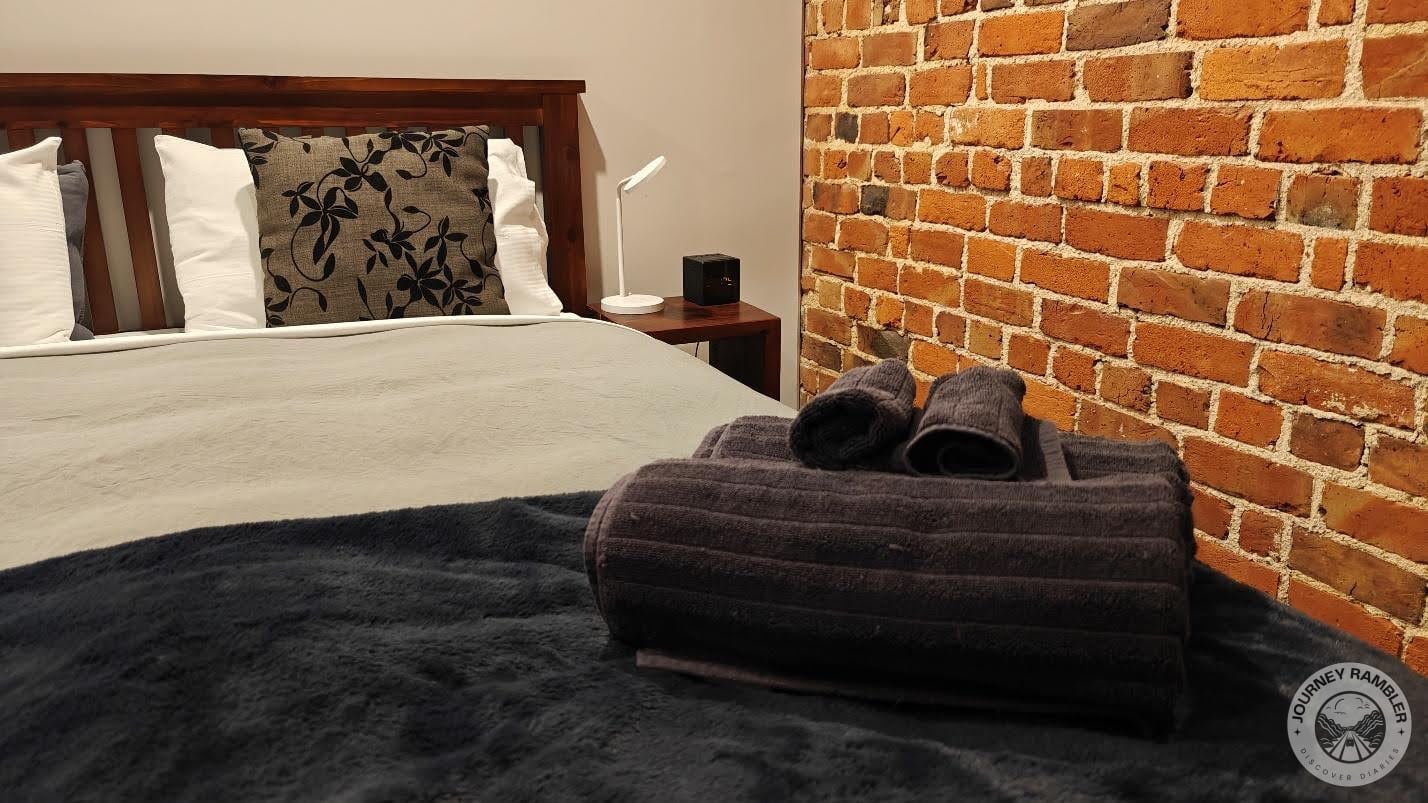 nightstands on either side of the bed and extra towels had been left on the bed