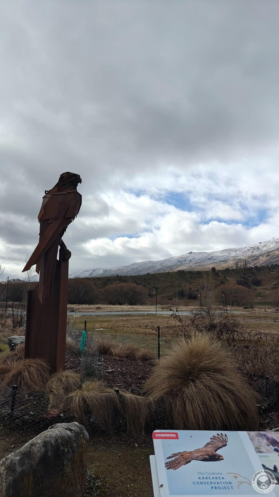 sculpture of a bird of prey on a wooden post