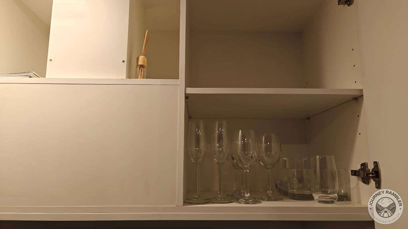some glasses in one of the cabinets