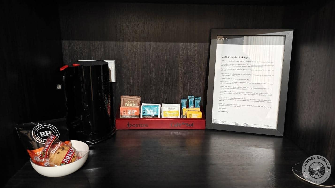 tea and coffee sachets and cookies along with a coffee maker