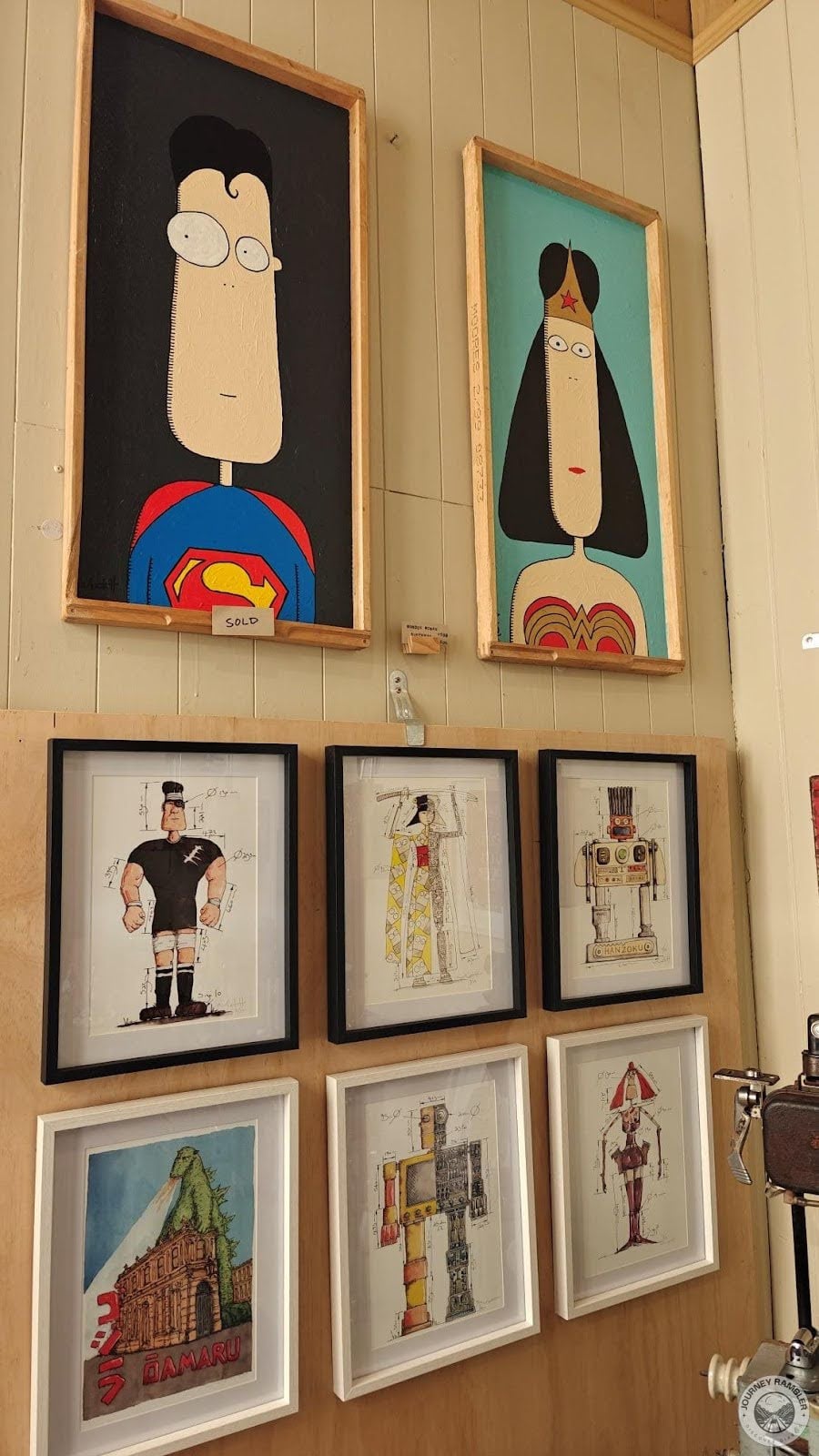 two paintings of Superman and Wonder Woman