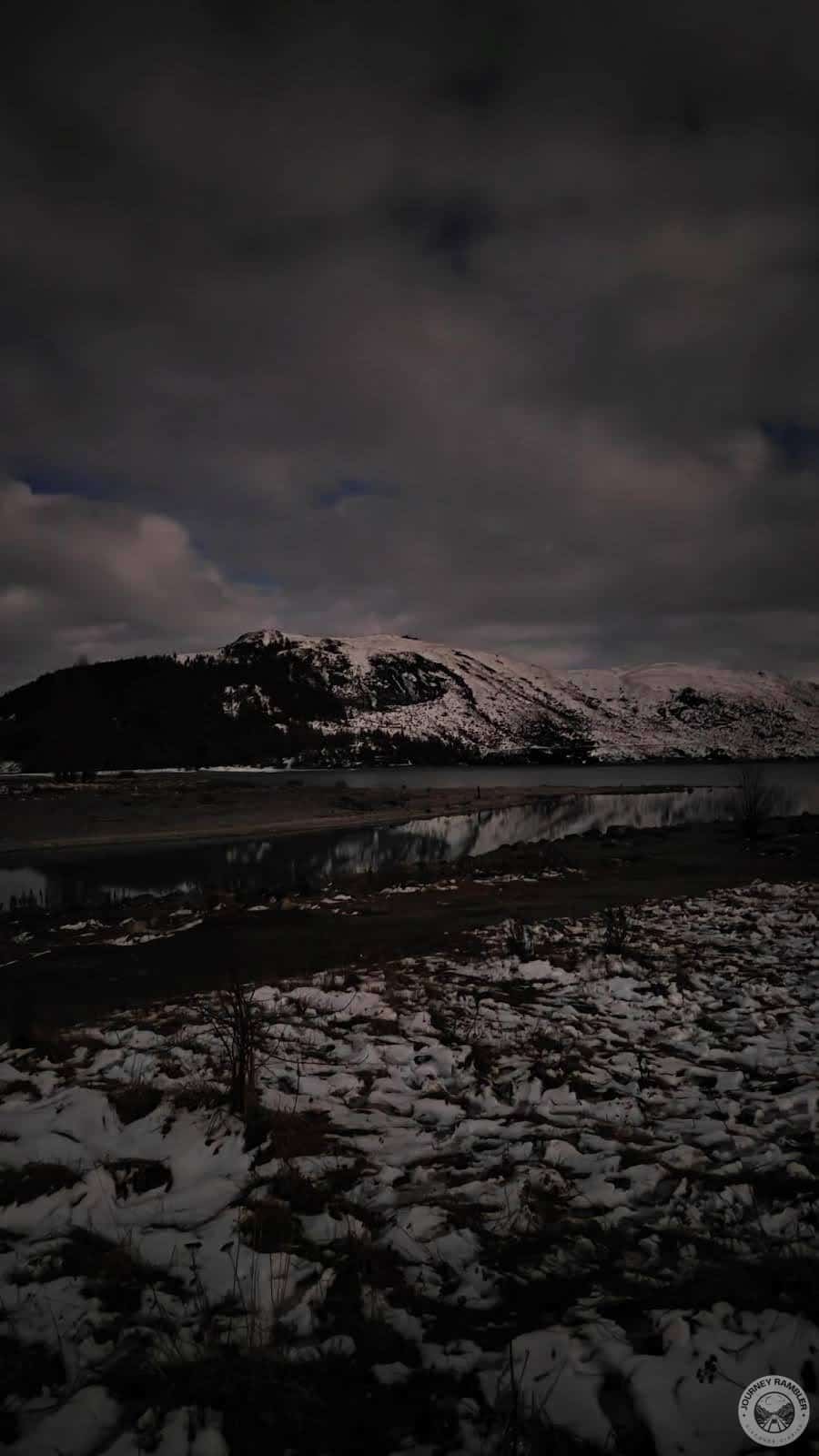 Even in the darkness, the water of the lake reflected the snowcapped mountains
