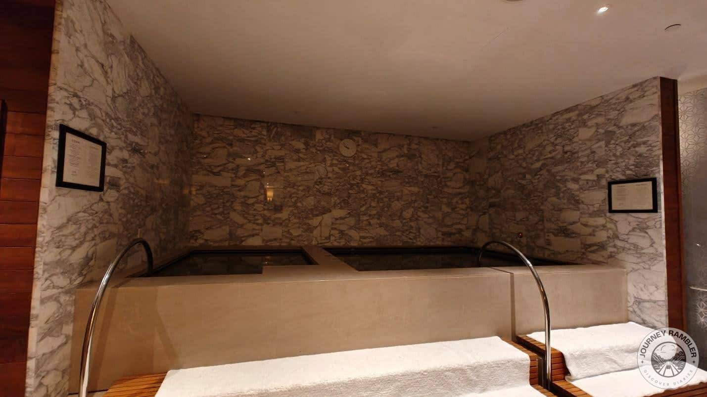 Jacuzzi in the changing room with marble walls on three sides