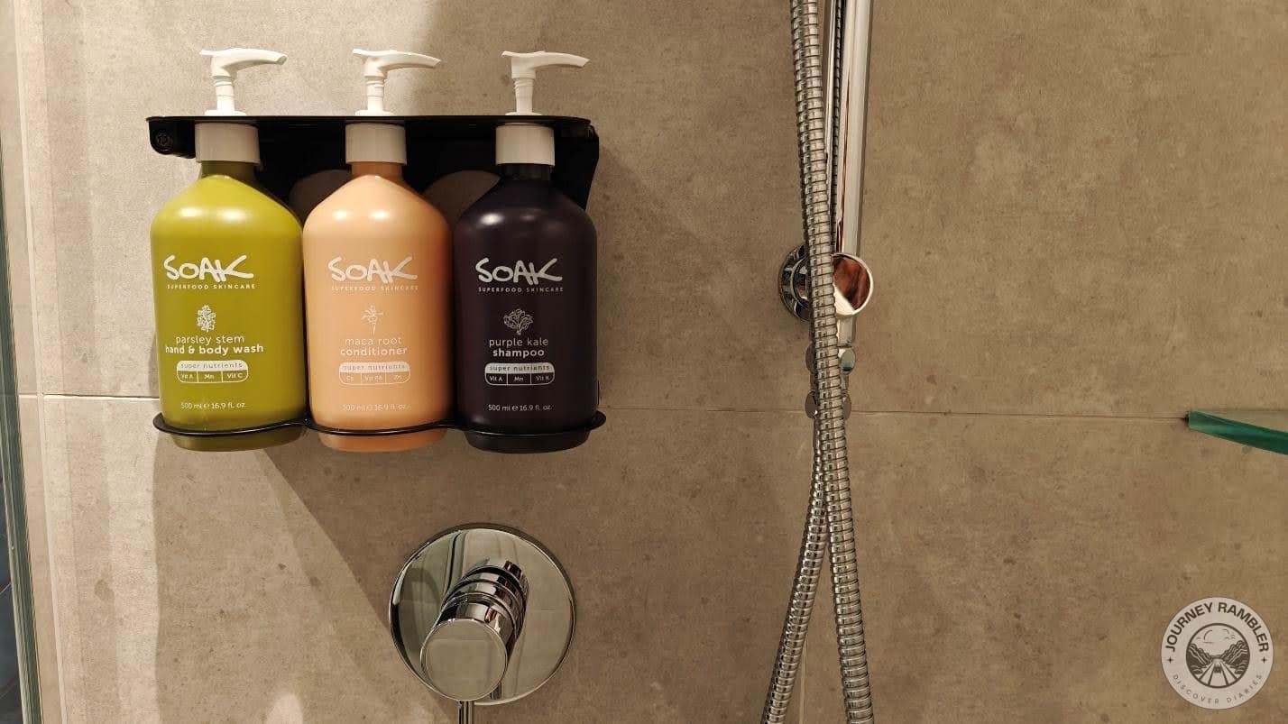 bottles of shampoo, conditioner and hand and body wash lined up in the shower