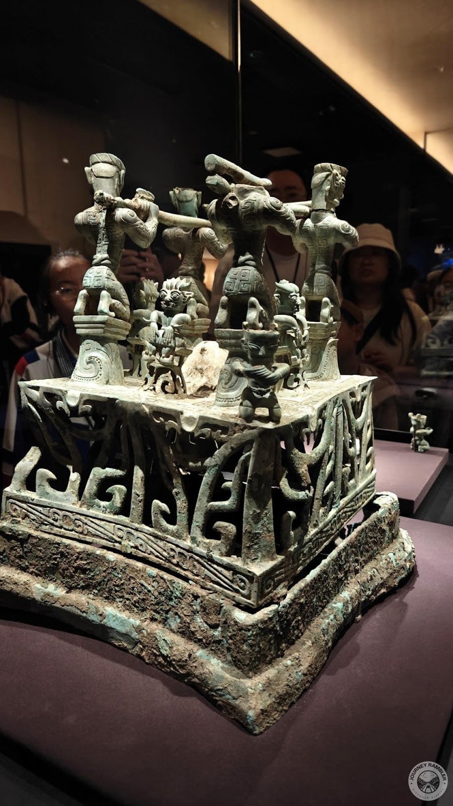 bronze statue with many human figurines on it