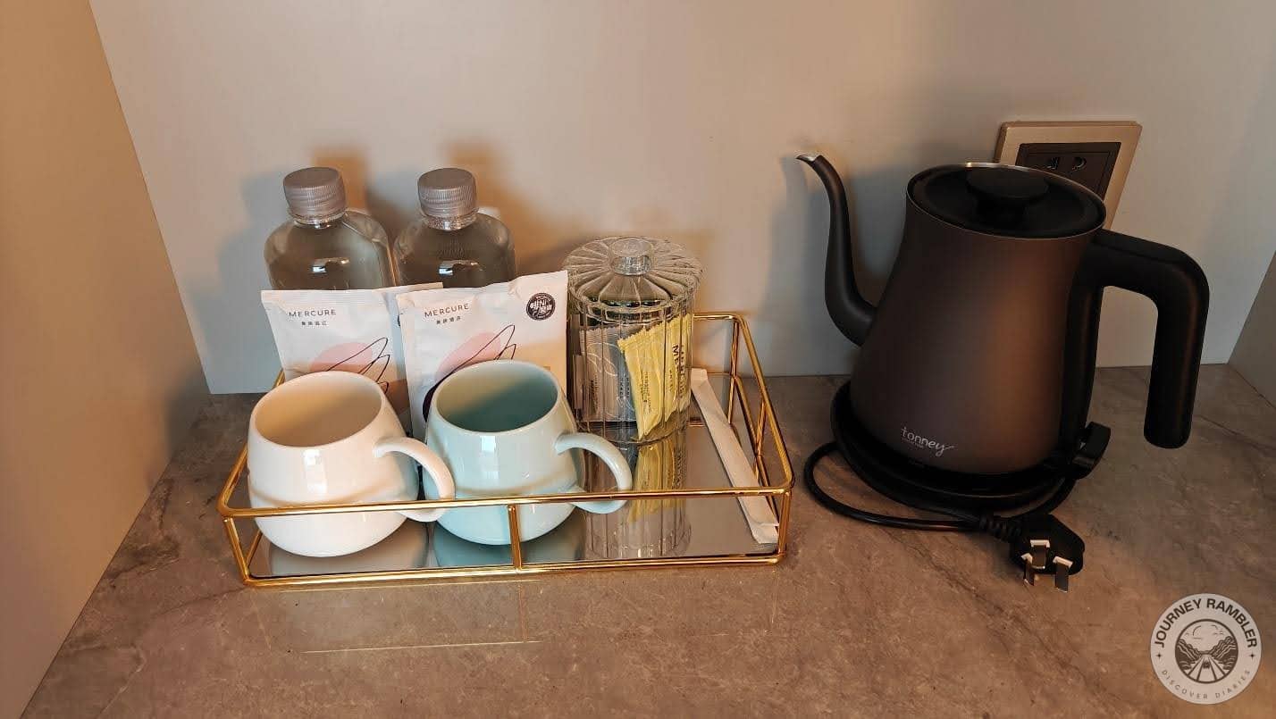 electric tea kettle, a couple of big mugs, some tea, coffee and sugar sachets and two bottles of water