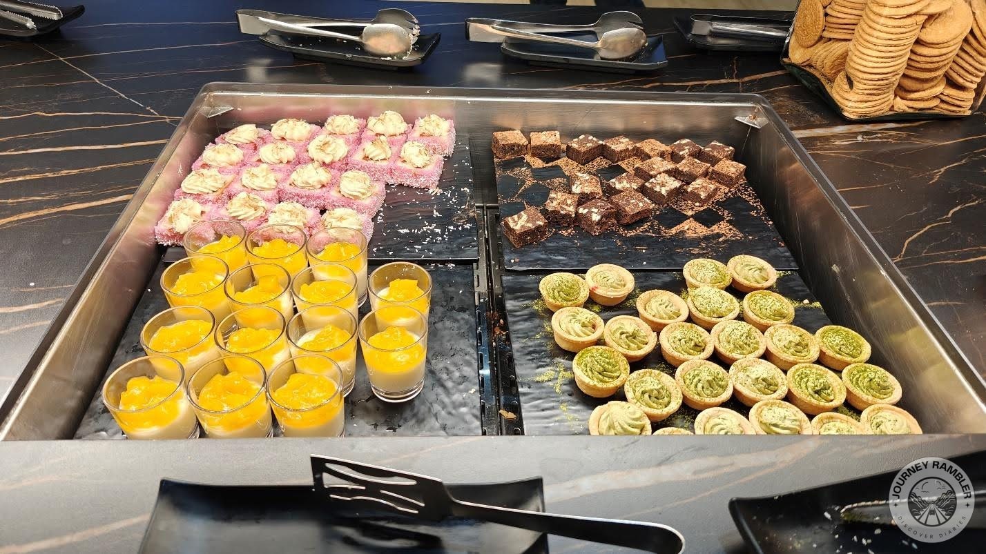 mango puddings in cups, chocolate brownies, tarts with custard inside and strawberry cakes