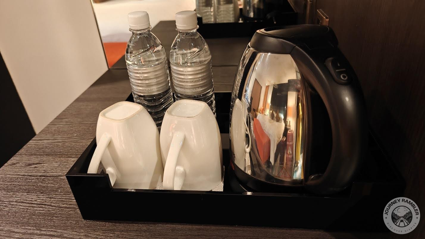 mini bar held a pair of mugs, water bottles and an electric kettle