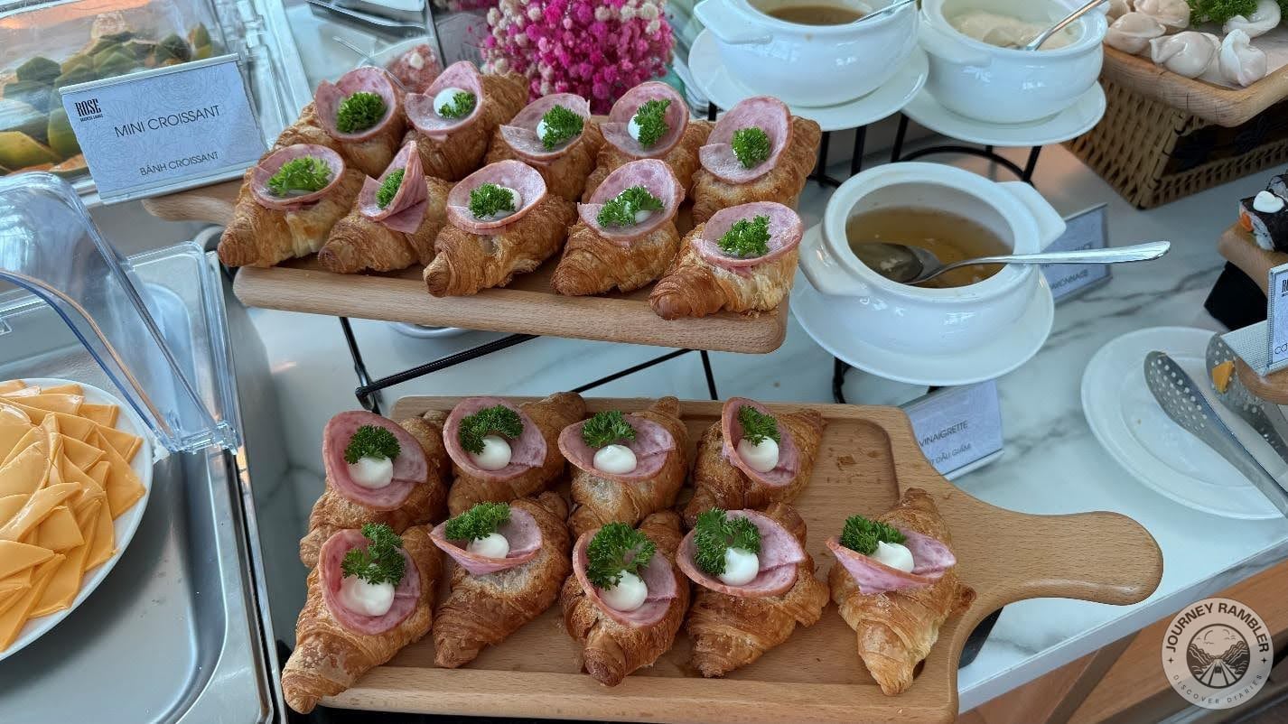 mini croissants topped with some ham, cheese and greens