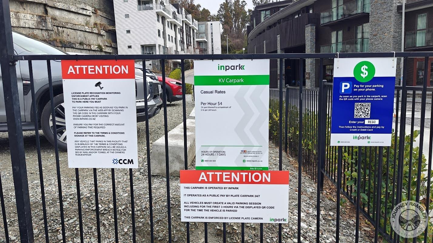 signs hung up on a fence at the parking lot