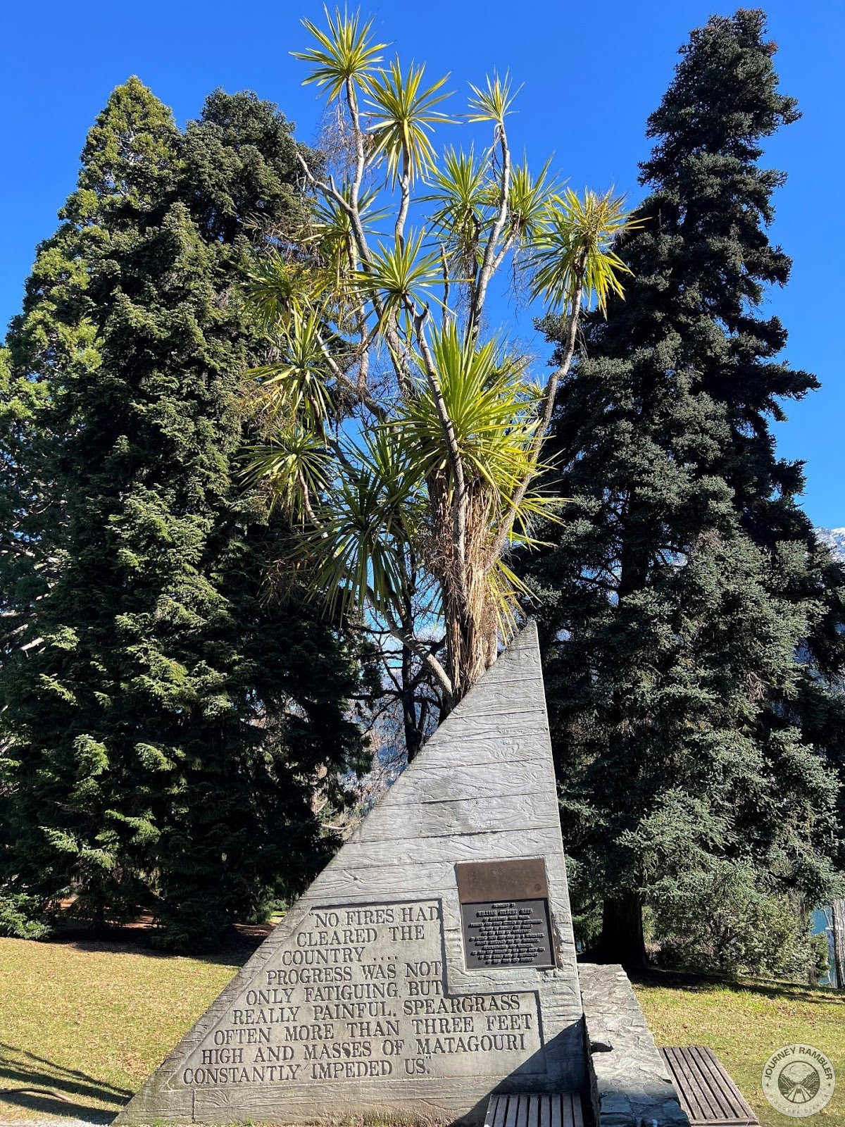 strange triangular structure in the middle of the lawn with some engravings on it
