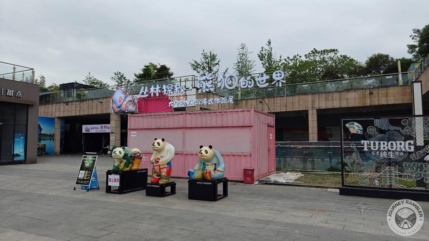 three much smaller statues of pandas sitting on boxes, painted in different colors