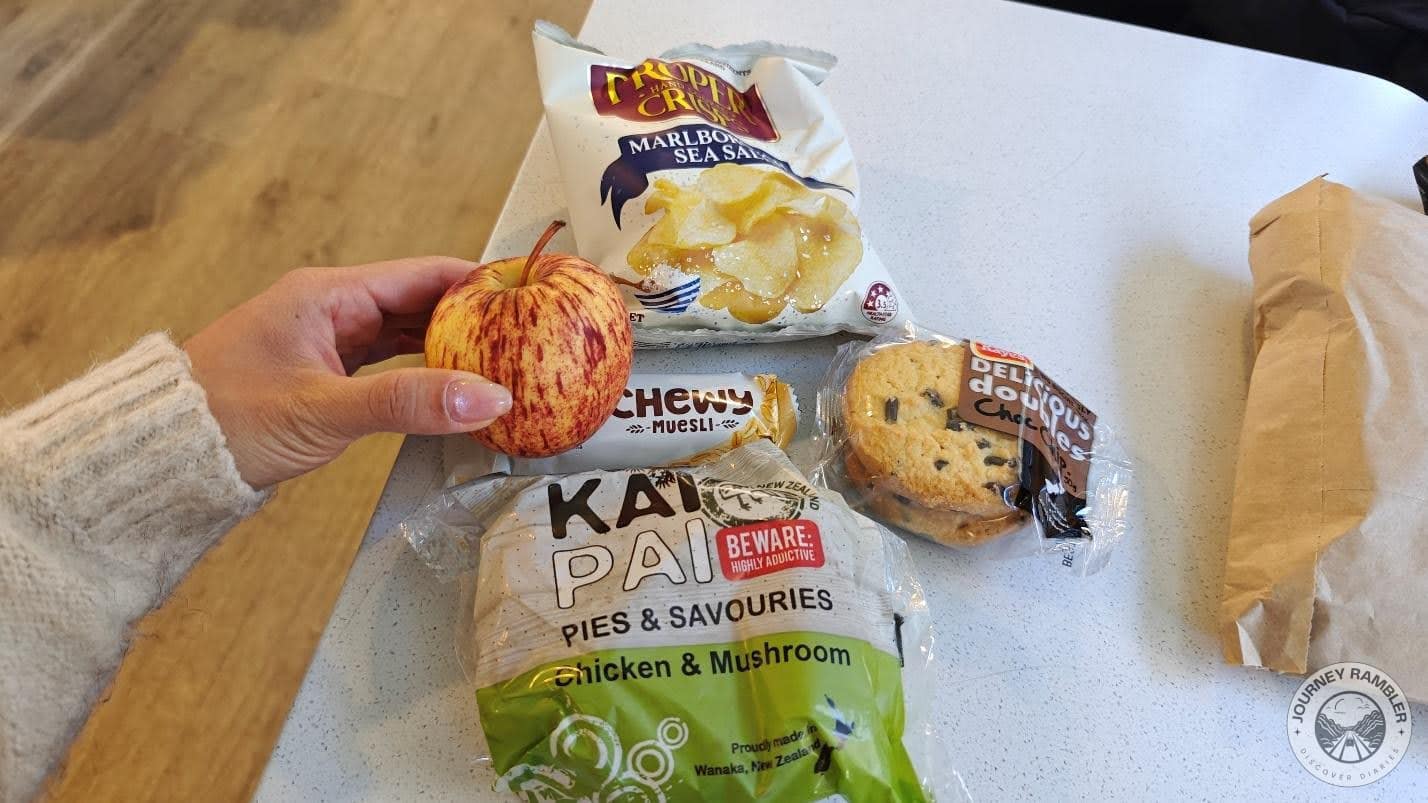 chicken and mushroom pie, some cookies, a cereal bar, a packet of sea salt chips and an apple