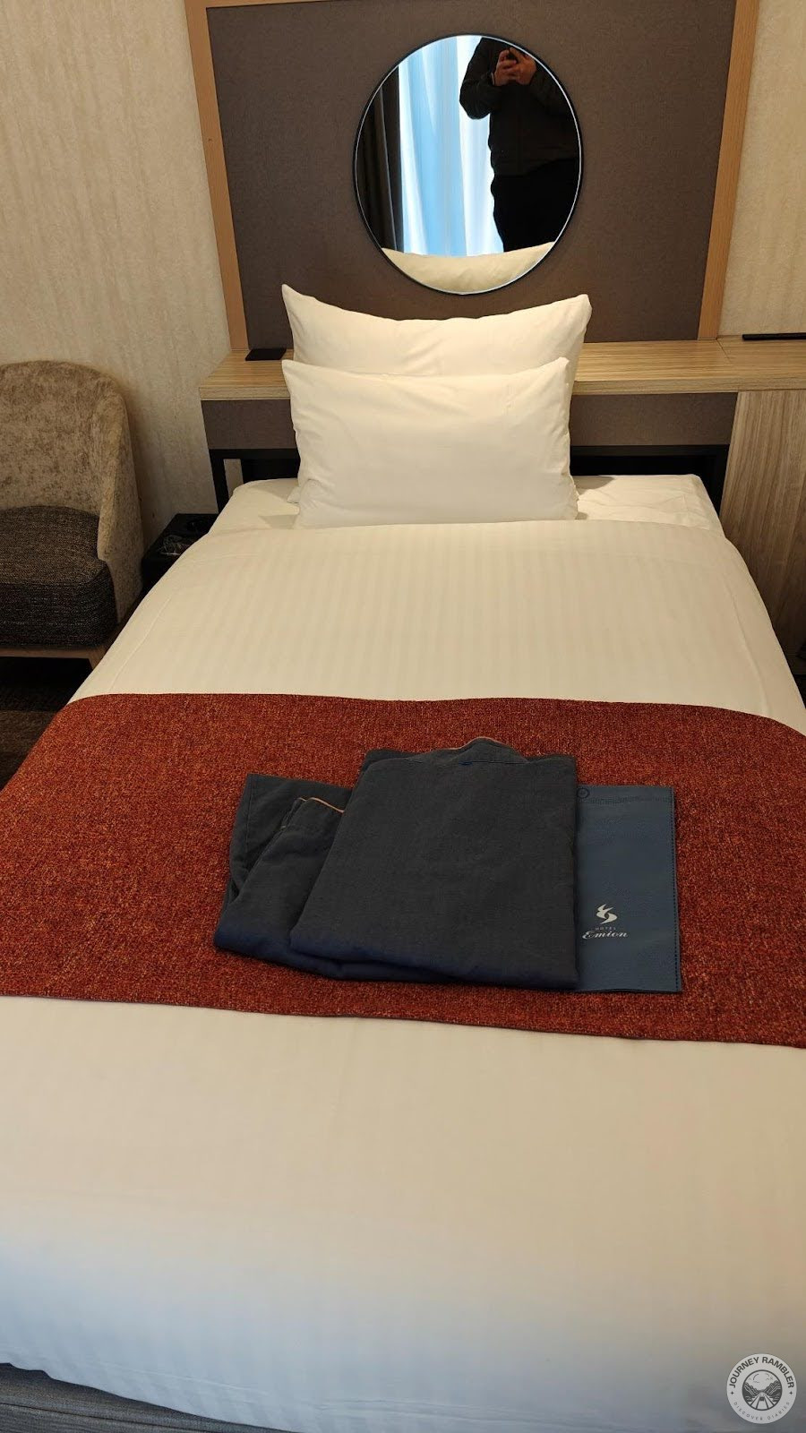 mirrors above the bed and pajamas and tote bags sitting on top of the beds