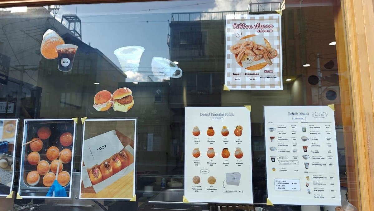 Bakery window with donut and drink menus, images of baked goods.