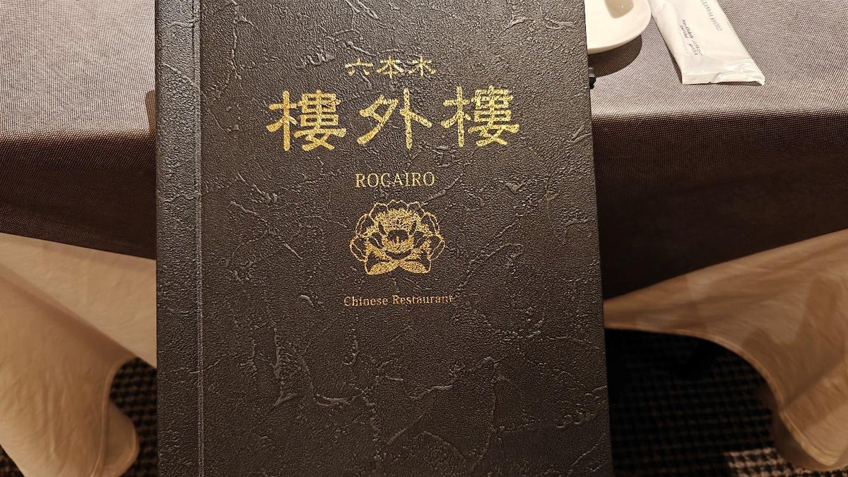 Dark menu with gold Chinese text, floral design, and restaurant name.