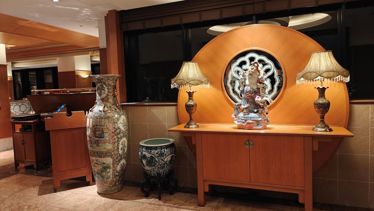 Elegant room with ornate vase, decorative statue, and table lamps.