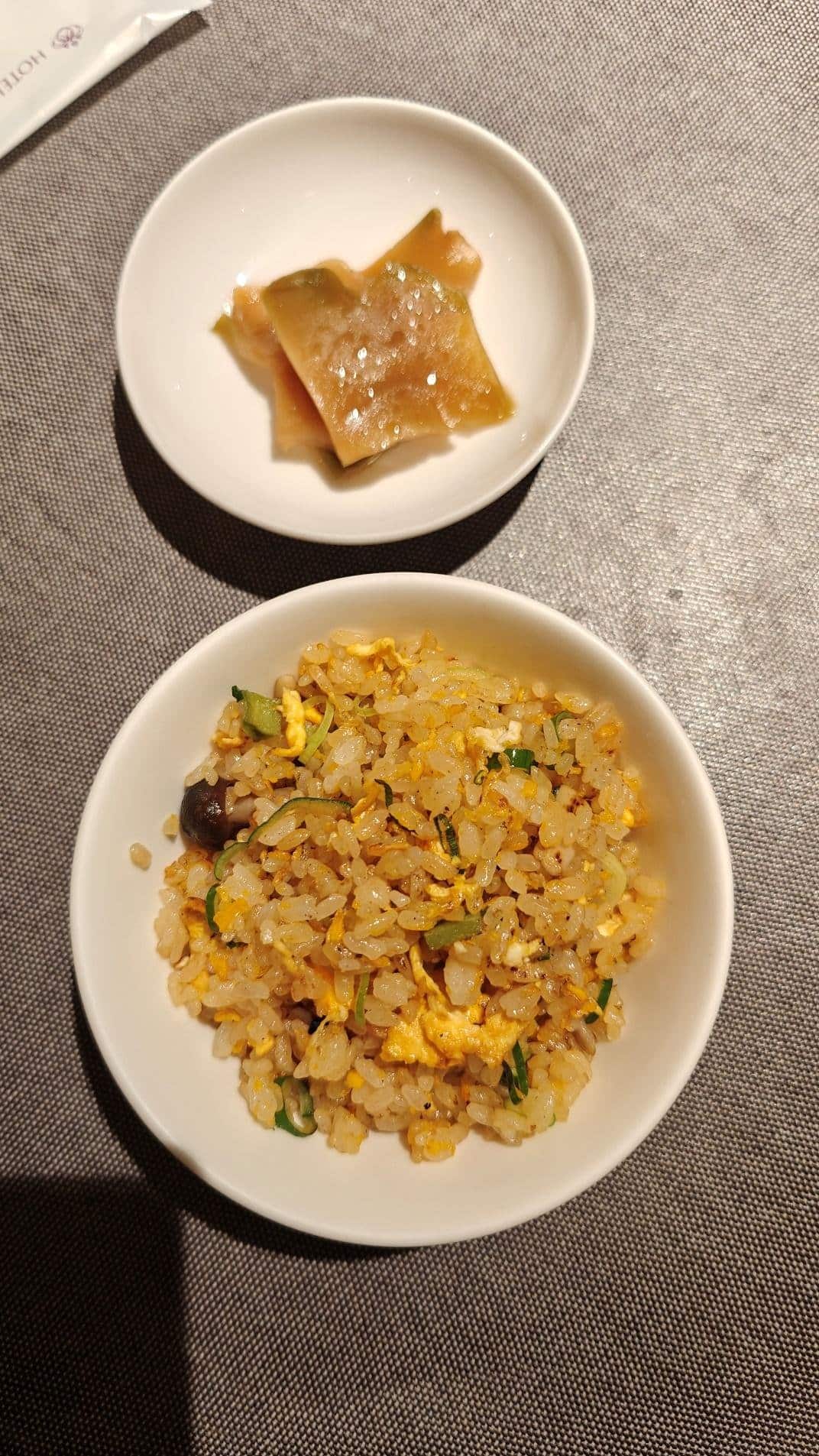 Fried rice with egg and herbs, pickled vegetables on a side dish.