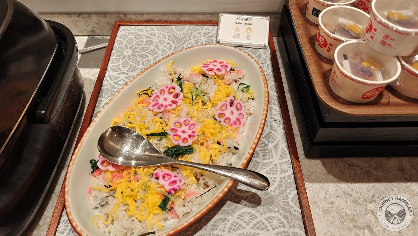 huge bowl filled with seasoned rice, cucumber, slices of radishes and eggs