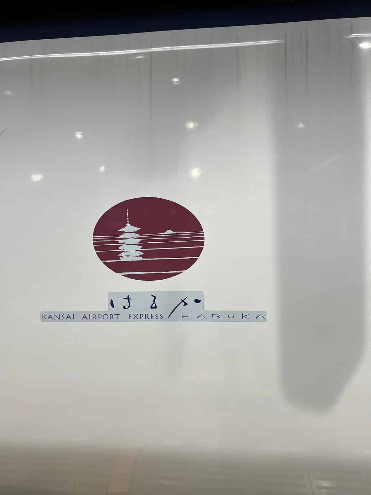 Kansai Airport Express Haruka logo with stylized pagoda in red circle.