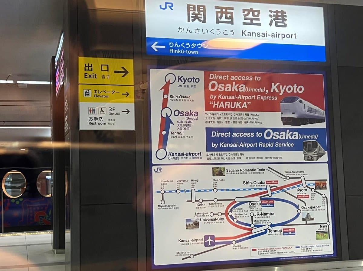 Kansai Airport train route map and exit signs in station.