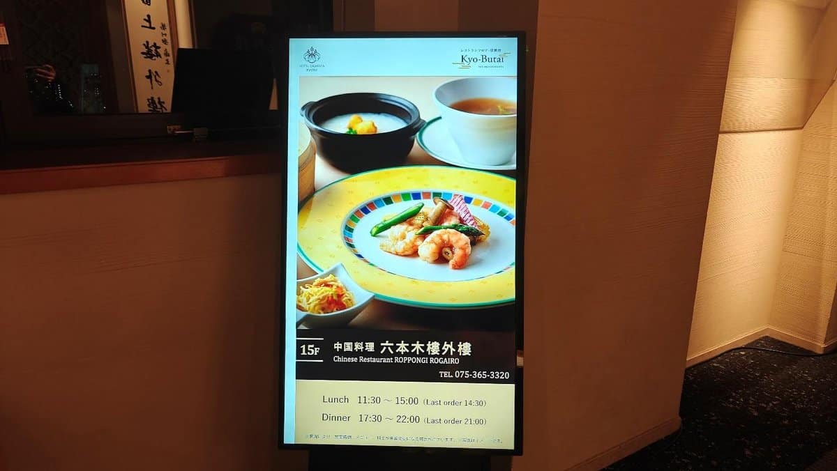 Restaurant digital menu with colorful dish and operating hours.