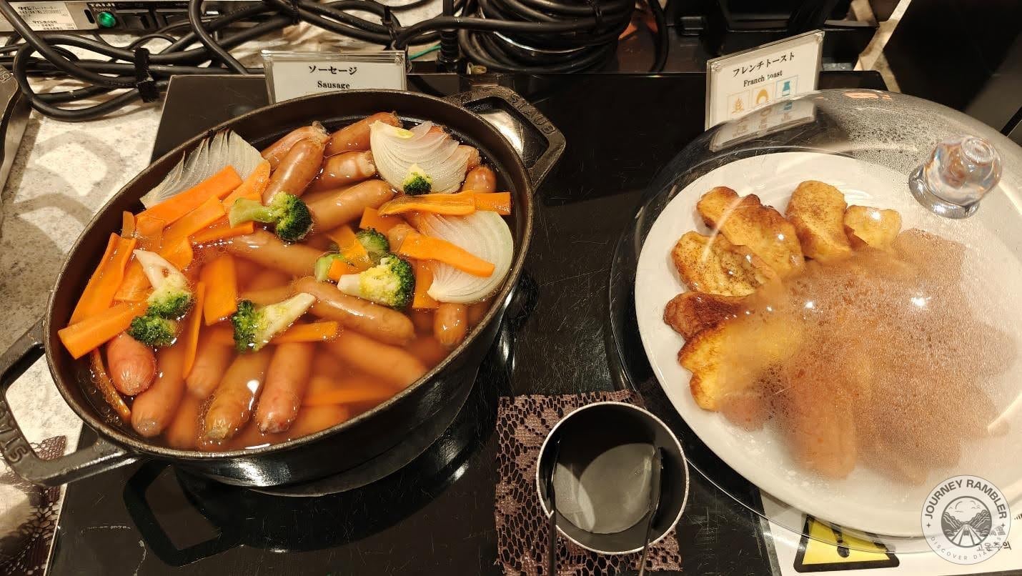 sausages were served alongside a wide variety of vegetables like carrots and broccoli