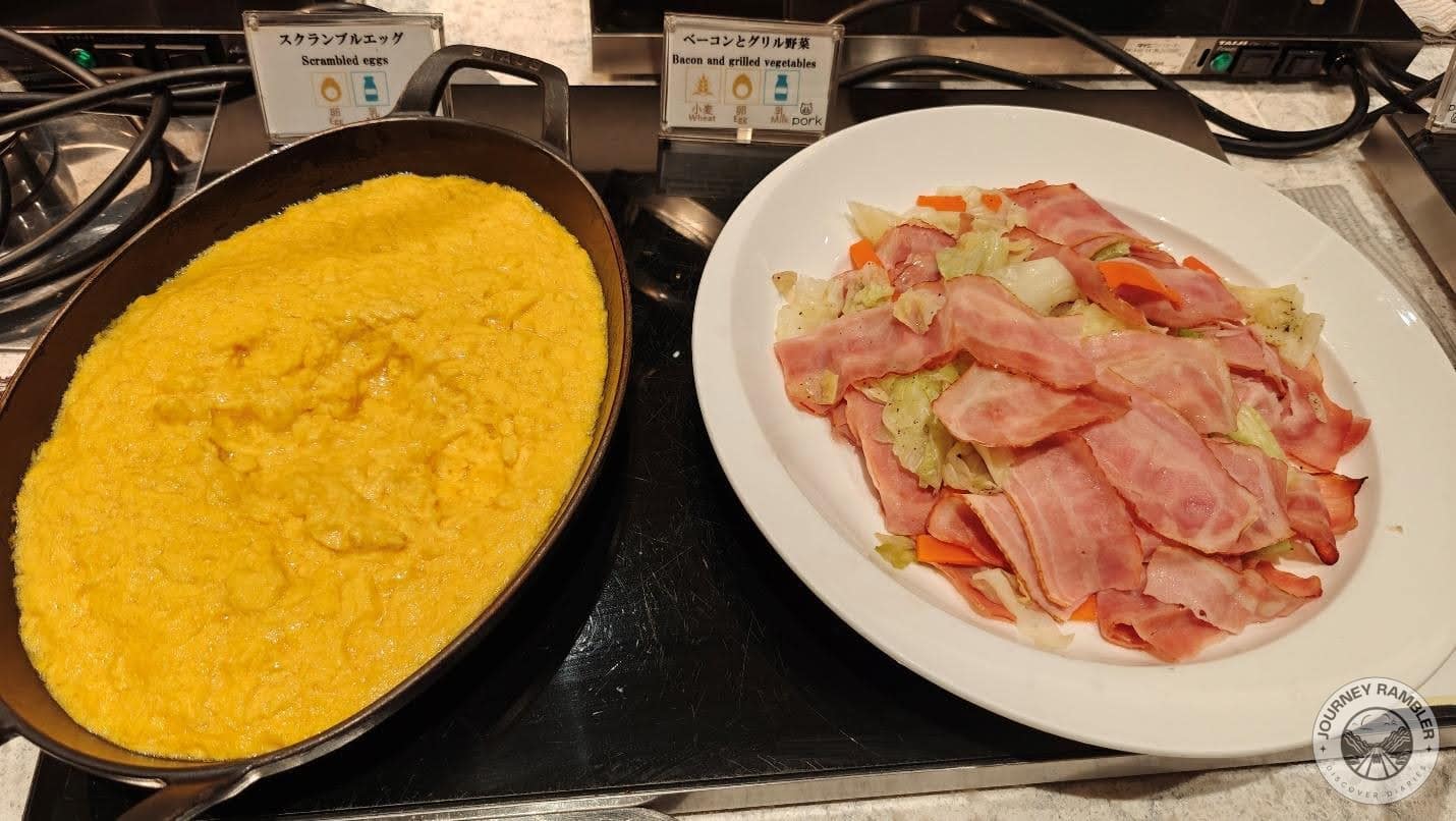 scrambled eggs and platter of bacon and grilled cabbages and carrots