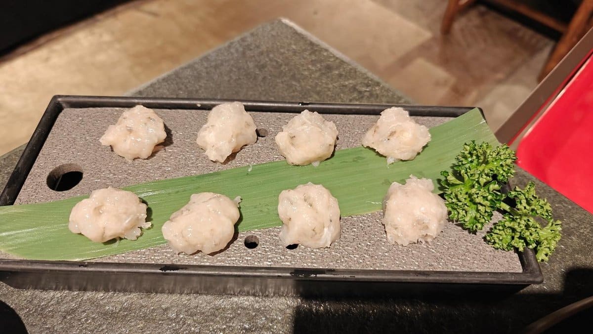 Steamed dumplings on a leaf, garnished with fresh parsley.