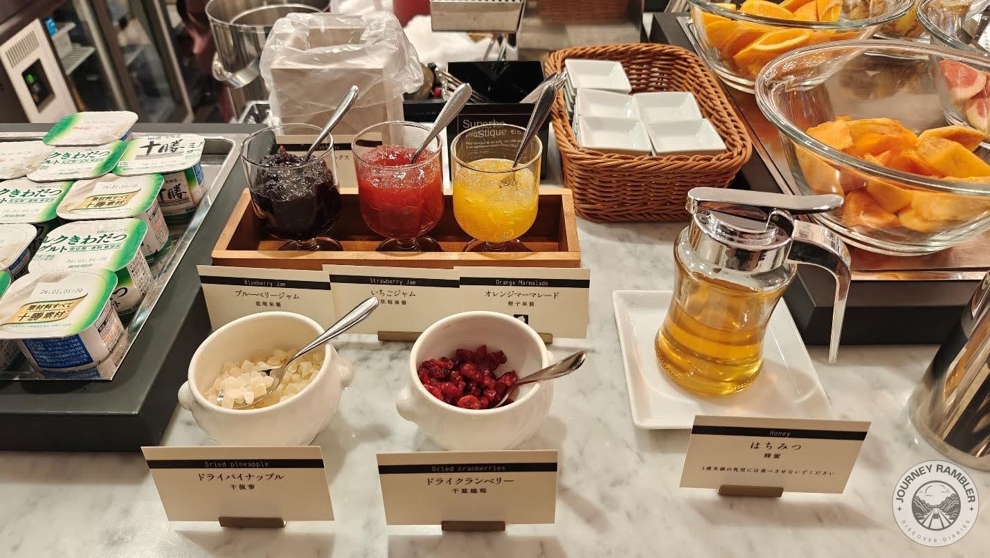 three different kinds of jam, like blueberry, strawberry and marmalade