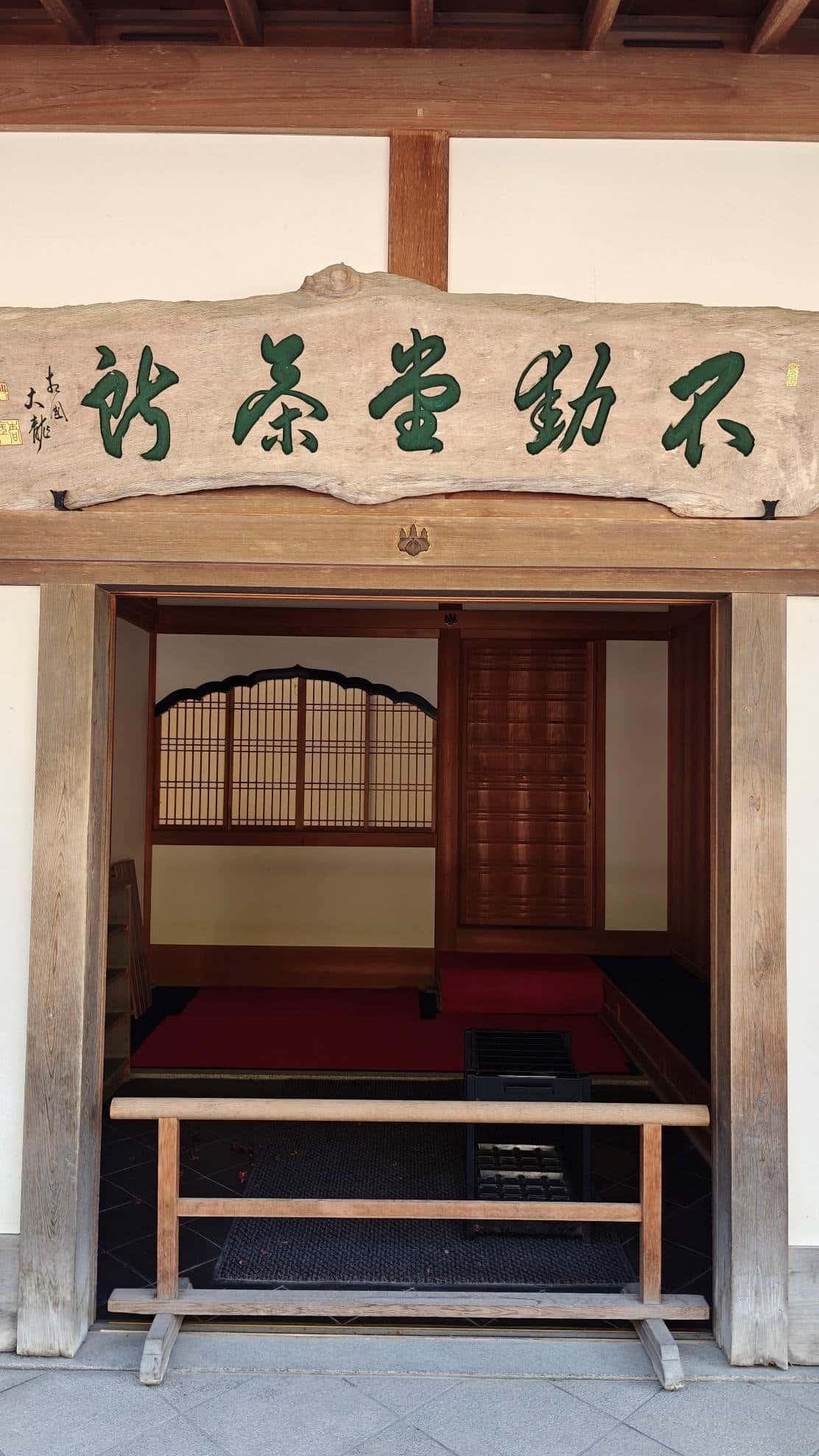 Traditional wooden entrance with Japanese calligraphy and sliding door.