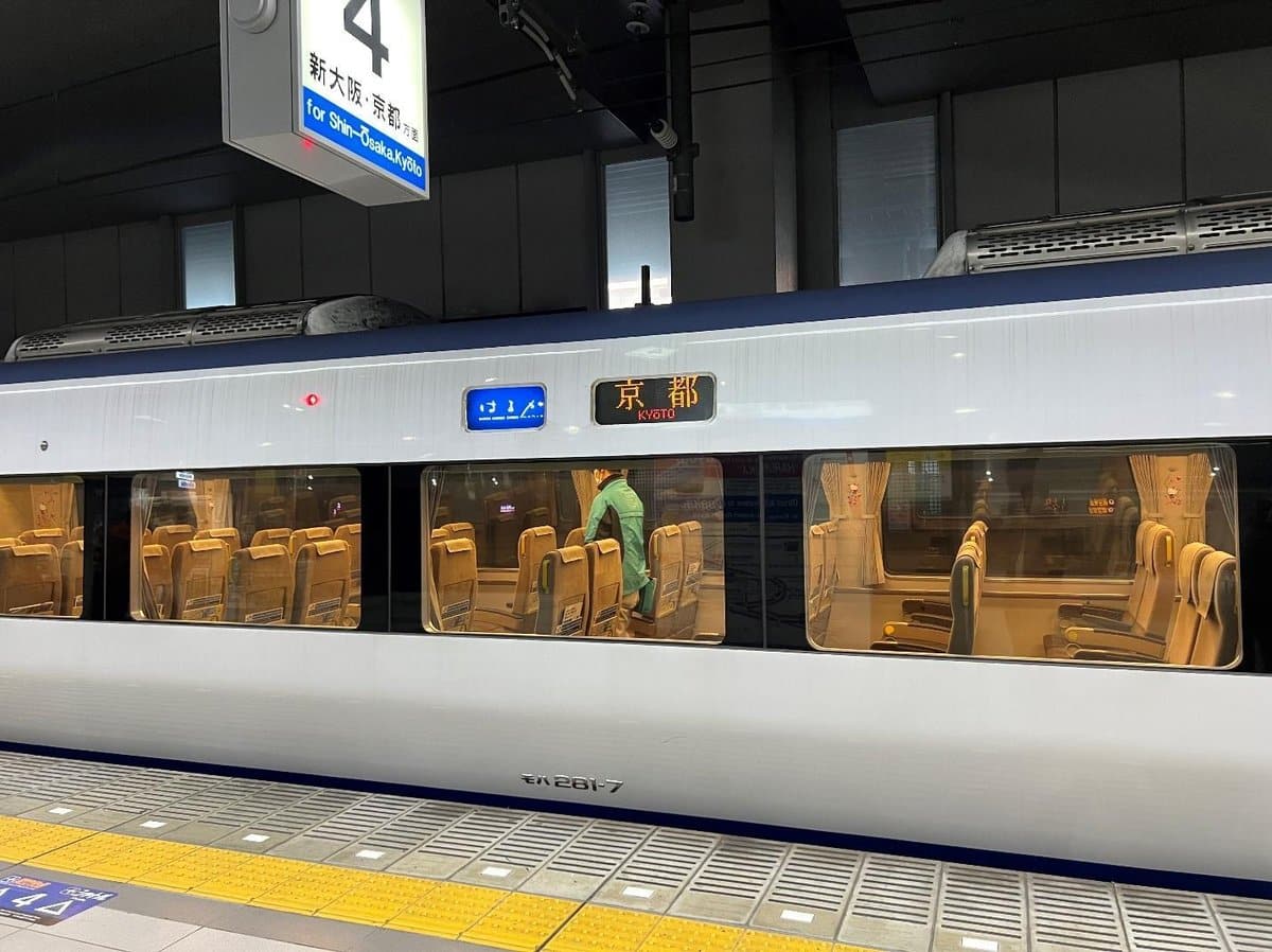 Train at platform with glowing Kyoto sign; empty seats visible inside.