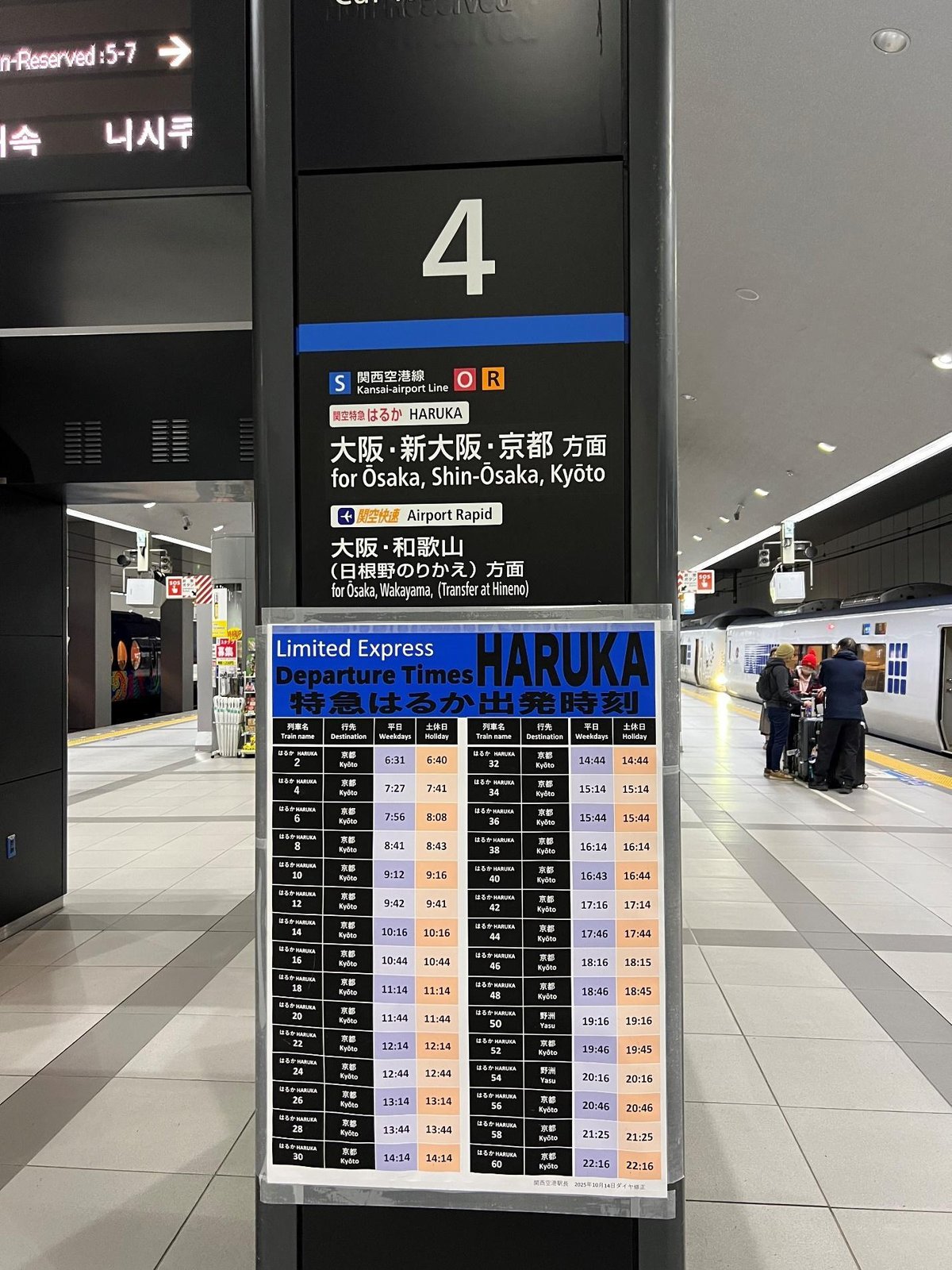 Train platform with schedule sign for Osaka, Shin-Osaka, Kyoto routes.