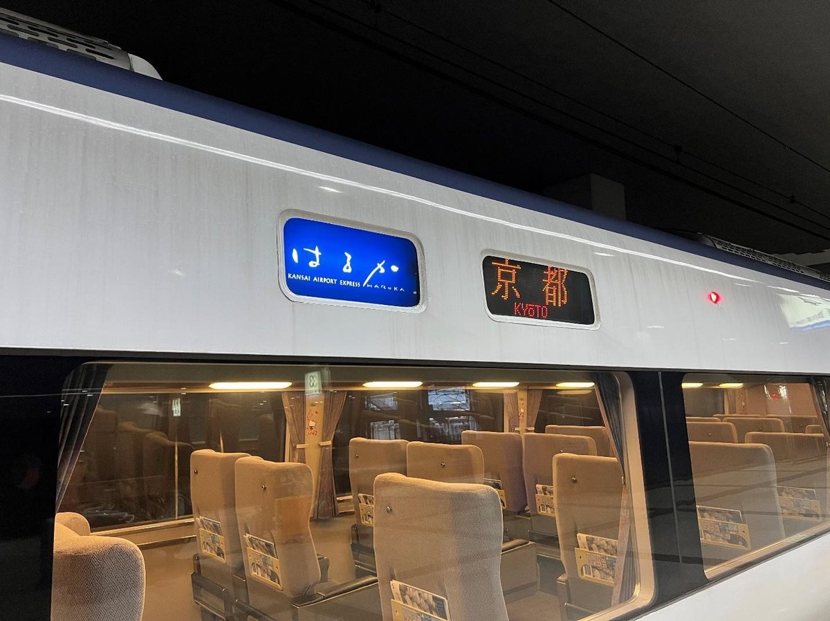 Train to Kyoto with empty beige seats and digital destination sign.