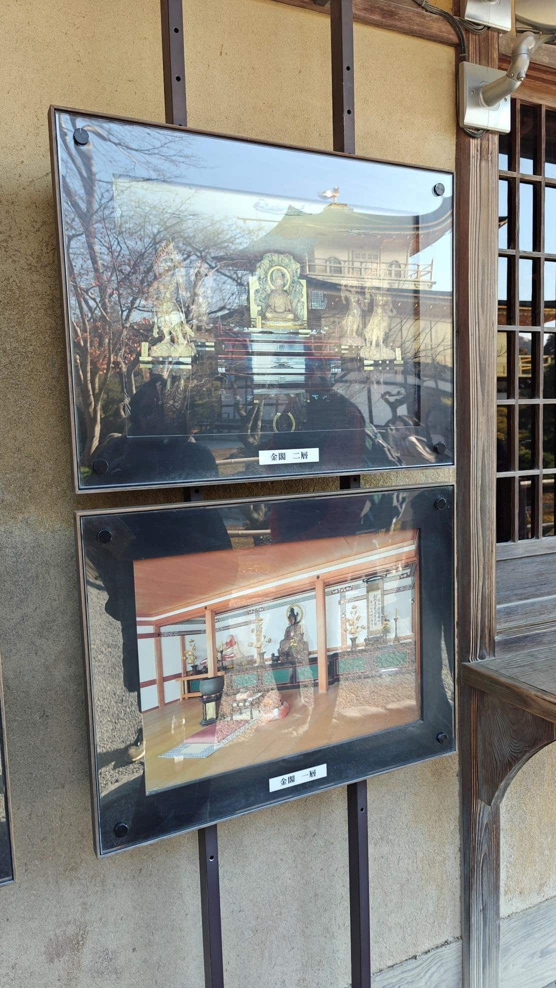 Two framed temple photographs displayed on an outdoor wall.