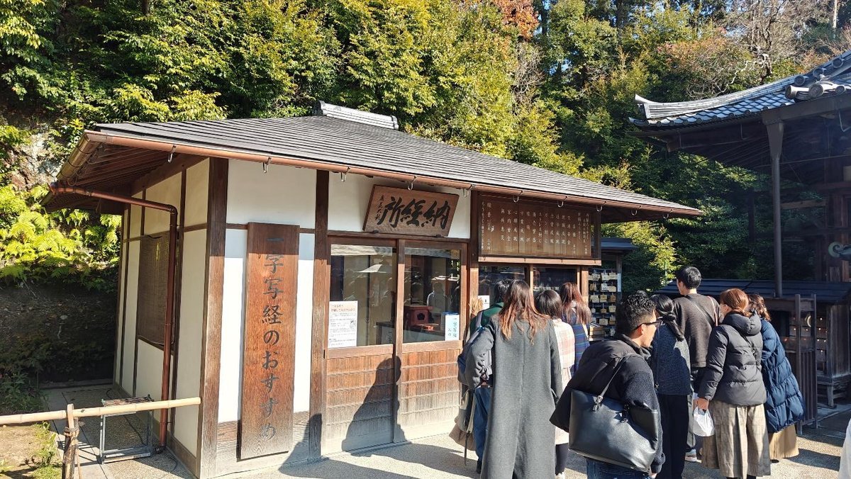 Visitors lined up at a traditional Japanese wooden booth.