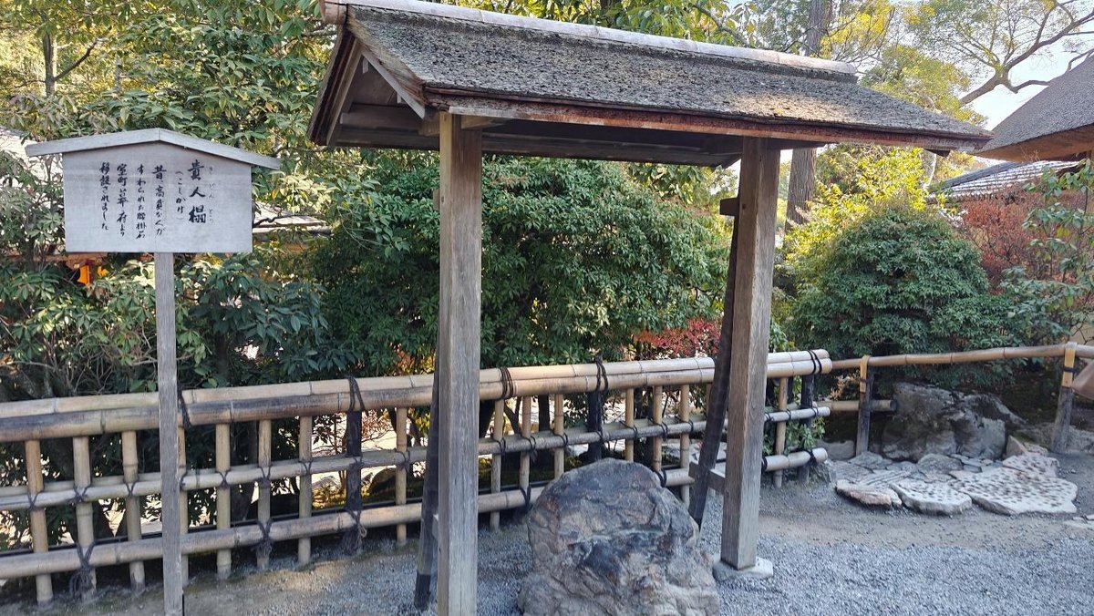Wooden gate in a serene Japanese garden with bamboo fence.