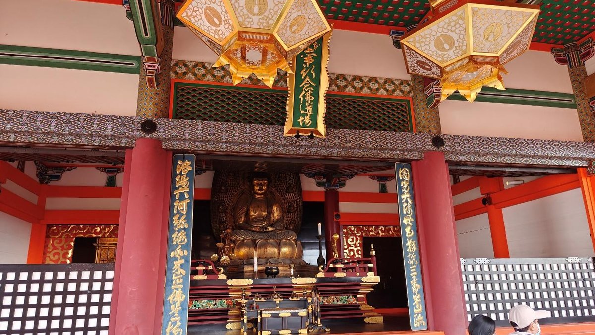Buddhist temple interior with ornate gold statue and decorations