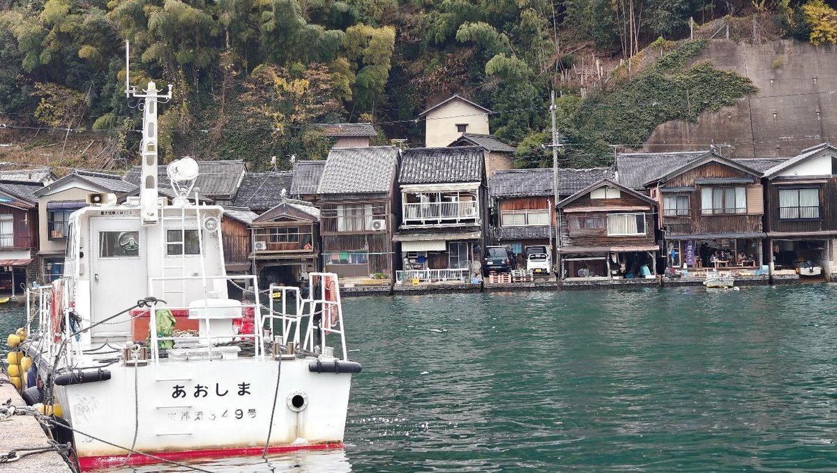 Coastal village houses with a docked boat in calm water